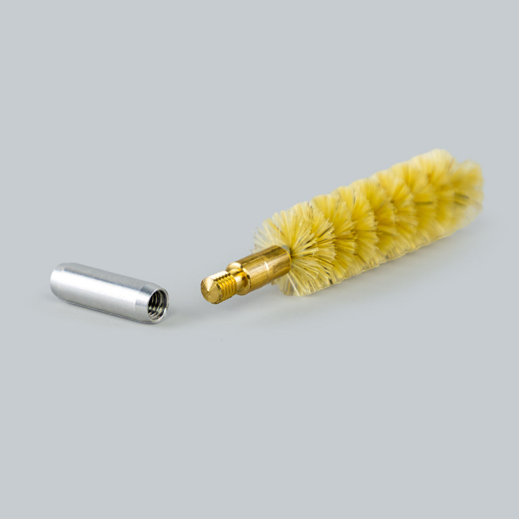 Cleaning brush with yellow bristles and a metal connector on a gray background